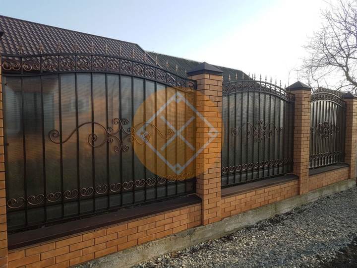 забор на фундаменте с металлическими секциями и ковкой